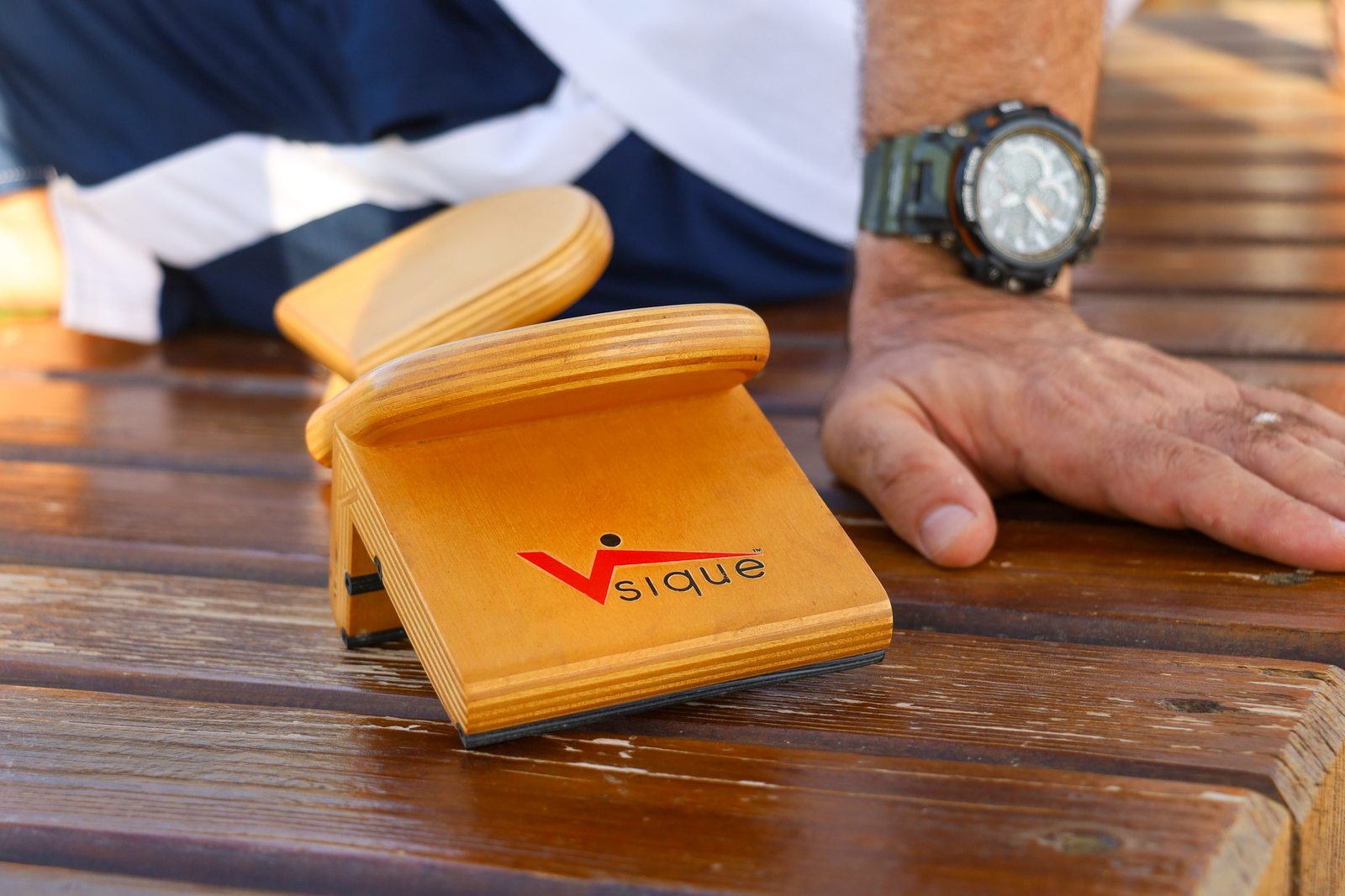 Close view of the original wooden Vsique device with its broad, angled palm rest